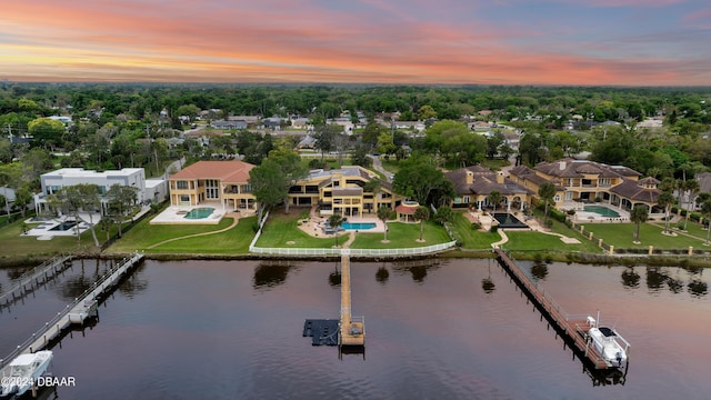 aerial view at dusk featuring a water view