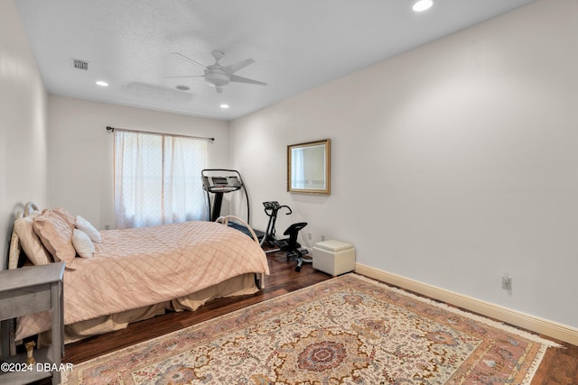 bedroom with ceiling fan, dark hardwood / wood-style flooring, and a textured ceiling