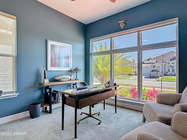 office area featuring a baseboard heating unit, carpet, and baseboards