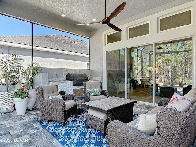 sunroom / solarium featuring a ceiling fan