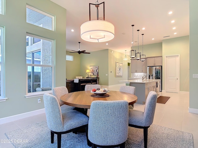 dining room with recessed lighting, light tile patterned flooring, and a towering ceiling