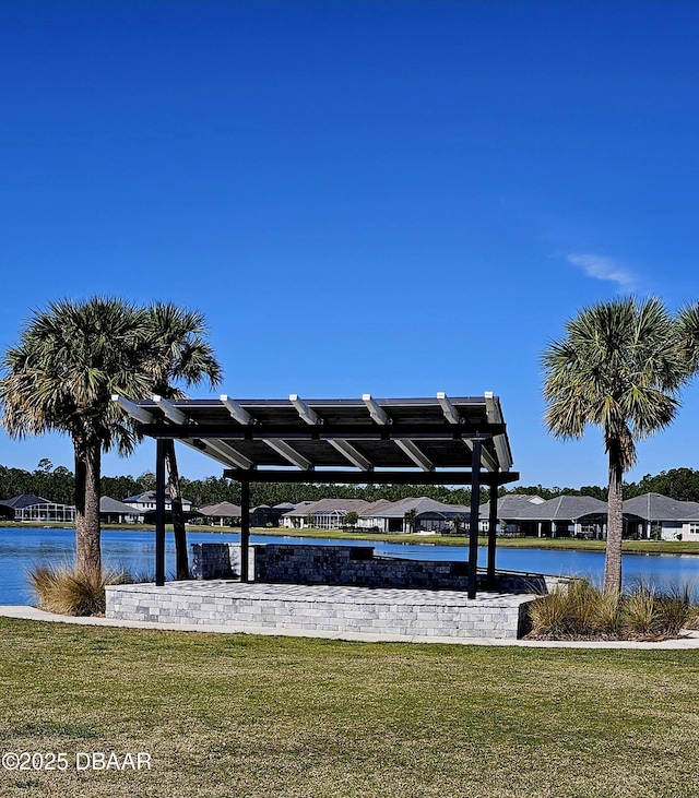 surrounding community with a water view and a lawn