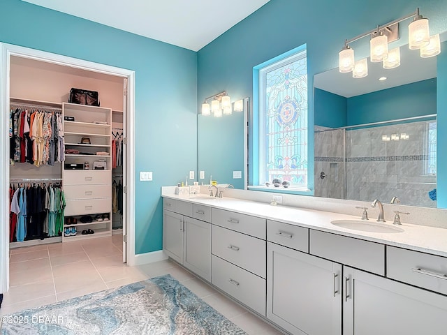 full bath featuring tile patterned flooring, a walk in closet, a sink, and tiled shower