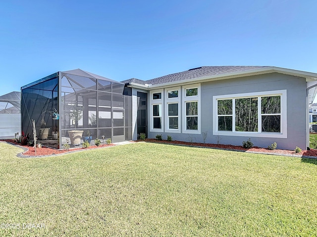 back of property with a shingled roof, a lawn, and stucco siding