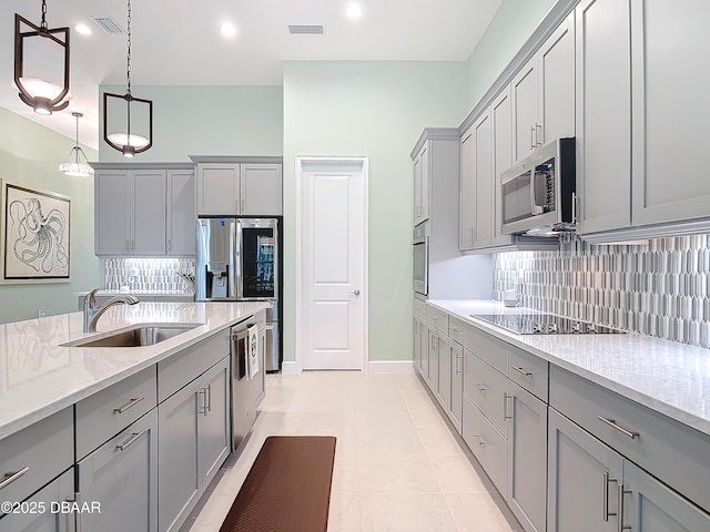 kitchen with stainless steel appliances, a sink, visible vents, and gray cabinetry