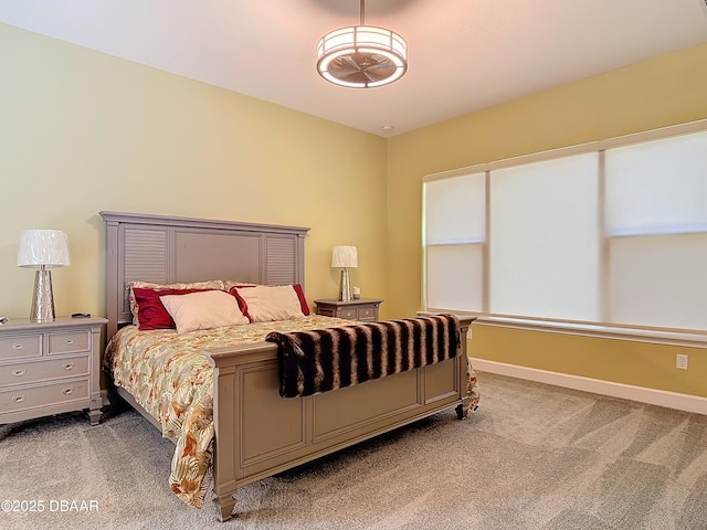 bedroom featuring light colored carpet and baseboards