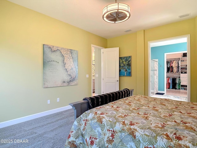 carpeted bedroom with visible vents, a spacious closet, and baseboards