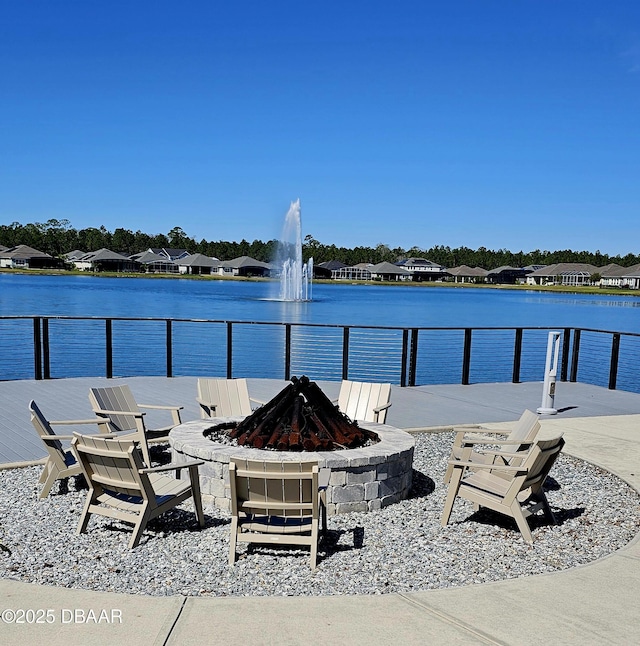 exterior space with a water view and a fire pit