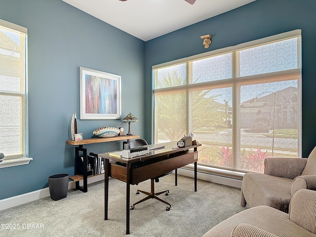 carpeted office with a baseboard heating unit and baseboards