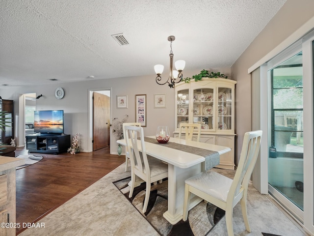 708 Egret Ct, Edgewater, FL 32141 - dining space with a textured ceiling, a chandelier, and light wood-style floors
