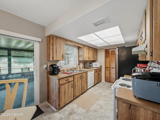 708 Egret Ct, Edgewater, FL 32141 - kitchen featuring white appliances, under cabinet range hood, light countertops, a sink, and light flooring