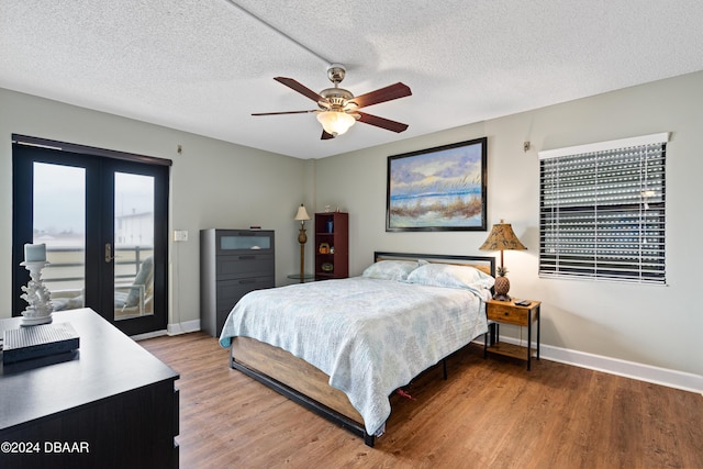 bedroom with french doors, wood-type flooring, a textured ceiling, and access to outside