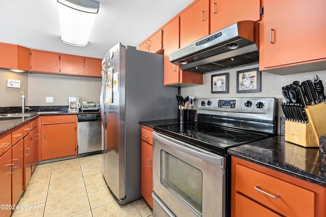 kitchen with appliances with stainless steel finishes, sink, dark stone countertops, exhaust hood, and light tile patterned floors