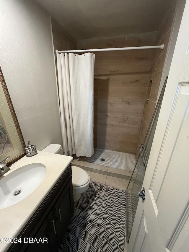 bathroom featuring walk in shower, tile patterned flooring, vanity, and toilet