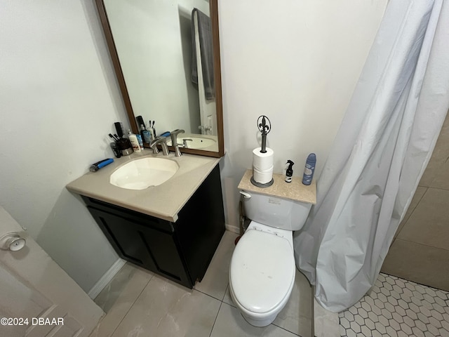 bathroom featuring tile patterned flooring, vanity, and toilet