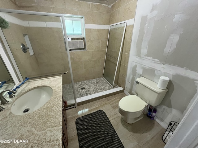 bathroom featuring tile patterned flooring, toilet, a shower with shower door, and sink