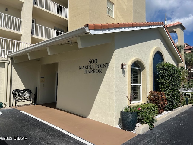 property entrance with a tiled roof and stucco siding