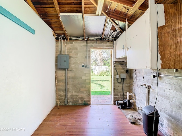 interior space featuring a garage, wood finished floors, and electric panel