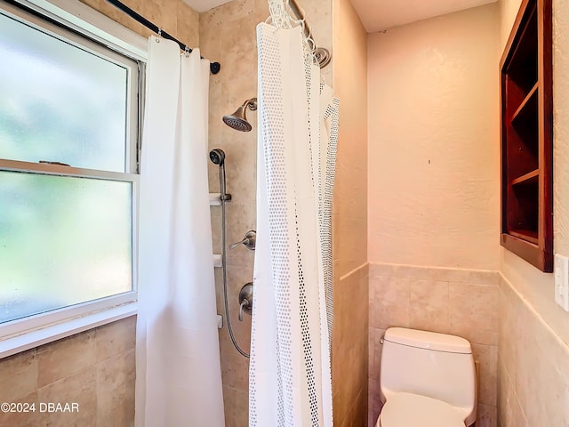 bathroom featuring toilet, tile walls, and a shower with shower curtain