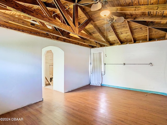 unfurnished room featuring light wood-type flooring, arched walkways, wooden ceiling, and vaulted ceiling with beams