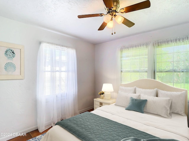 bedroom with a ceiling fan and baseboards