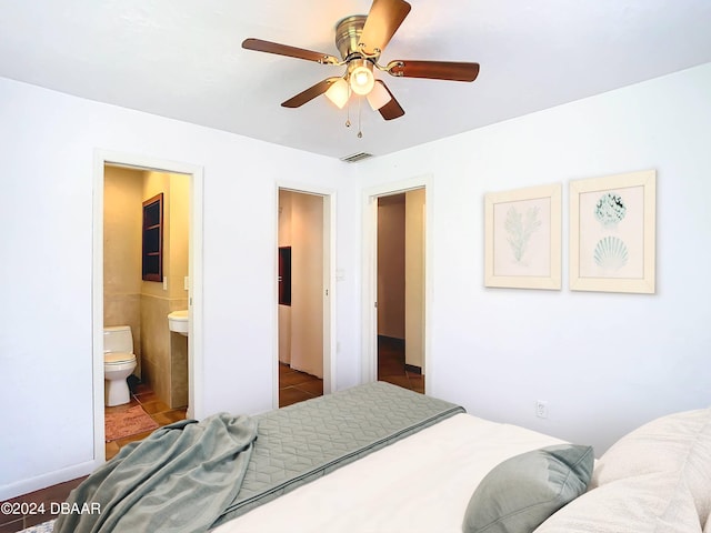 tiled bedroom featuring ceiling fan, connected bathroom, and visible vents