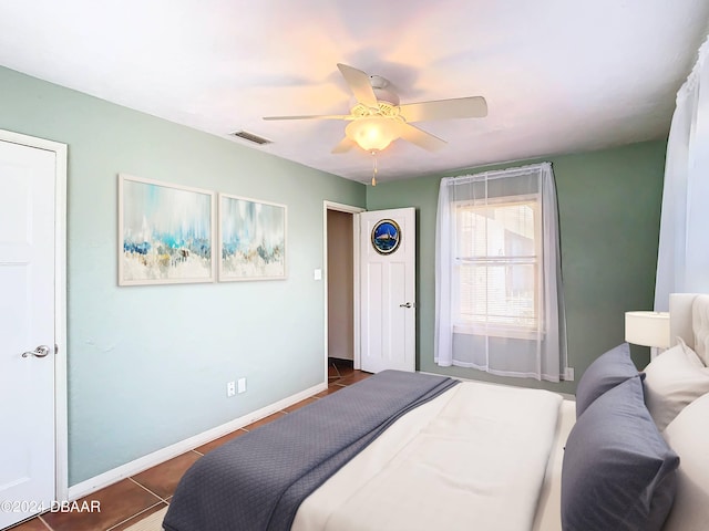 tiled bedroom with ceiling fan, visible vents, and baseboards