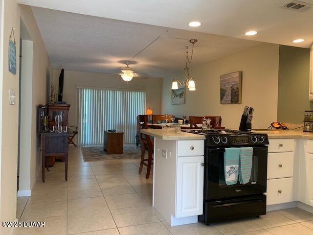 325 Causeway Cswy N Unit D104, New Smyrna Beach, FL 32169 - kitchen with white cabinetry, light countertops, visible vents, and black gas stove