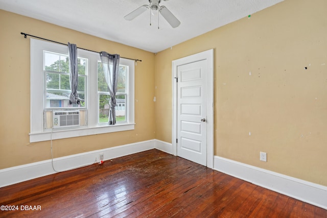 empty room featuring ceiling fan, a textured ceiling, cooling unit, and dark hardwood / wood-style flooring