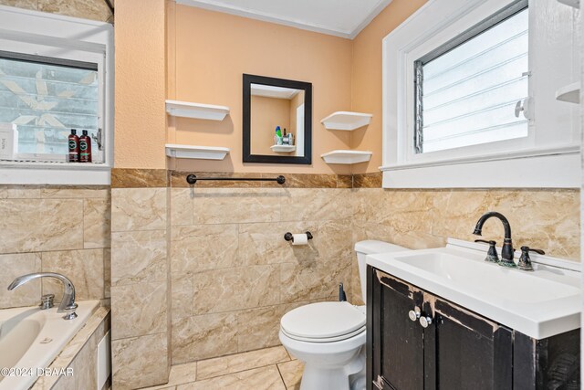 bathroom with tile walls, a washtub, and vanity