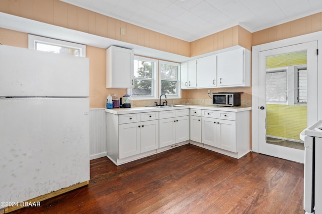 kitchen with white cabinetry, plenty of natural light, and white appliances