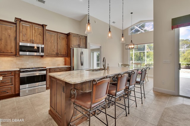 1329 Sunningdale Ln, Ormond Beach, FL 32174 - kitchen with appliances with stainless steel finishes, light tile patterned floors, backsplash, light stone countertops, and decorative light fixtures