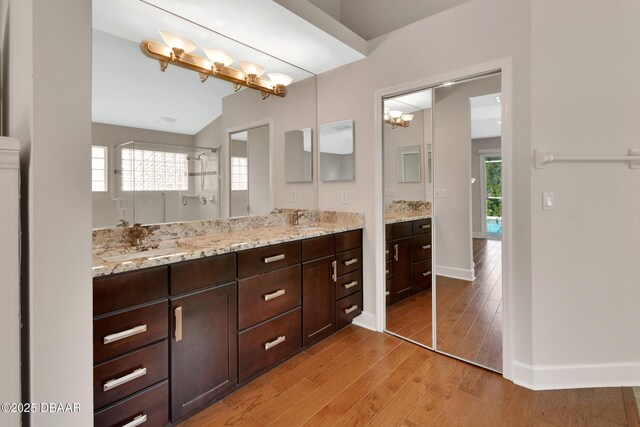 1329 Sunningdale Ln, Ormond Beach, FL 32174 - bathroom featuring double vanity, wood finished floors, walk in shower, and vaulted ceiling