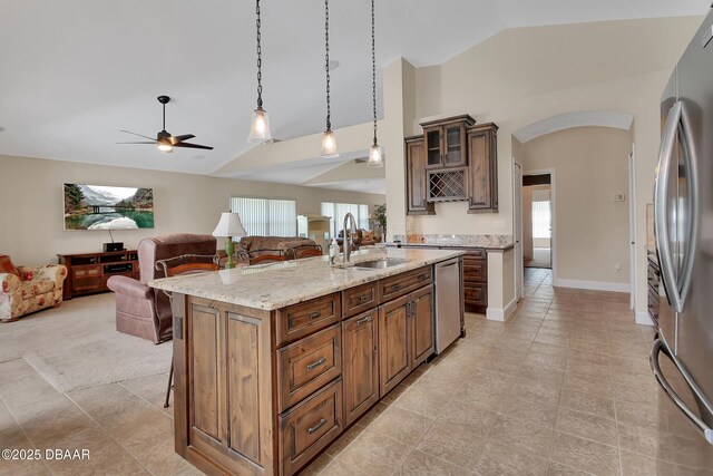 1329 Sunningdale Ln, Ormond Beach, FL 32174 - kitchen featuring open floor plan, appliances with stainless steel finishes, a kitchen bar, arched walkways, and plenty of natural light