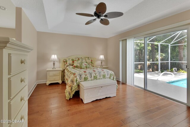 1329 Sunningdale Ln, Ormond Beach, FL 32174 - bedroom with access to exterior, wood finished floors, a sunroom, a ceiling fan, and a tray ceiling