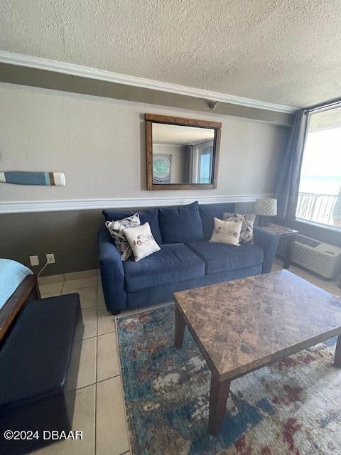 tiled living room with cooling unit, a textured ceiling, and ornamental molding