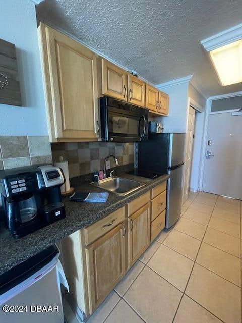 kitchen with decorative backsplash, a textured ceiling, sink, light tile patterned floors, and crown molding