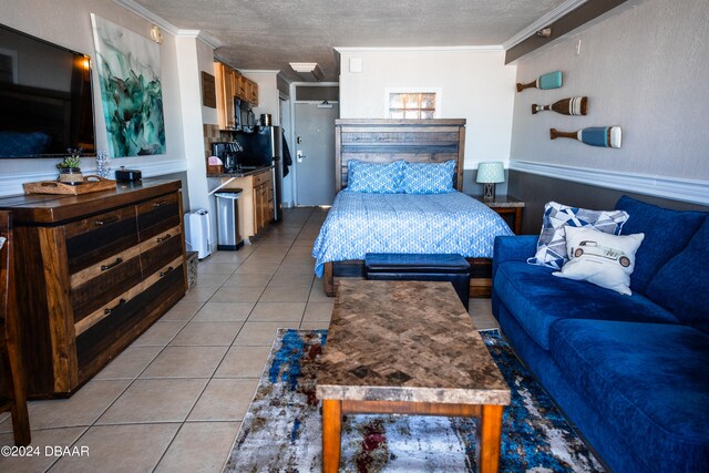 bedroom featuring ornamental molding, a textured ceiling, and light tile patterned floors