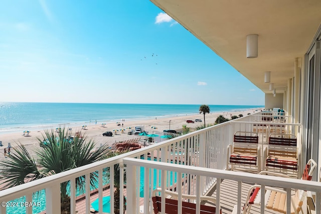 balcony featuring a beach view and a water view