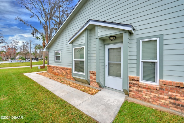 view of exterior entry with a lawn