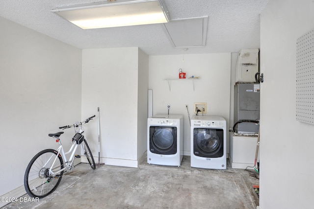 laundry room with a textured ceiling and separate washer and dryer