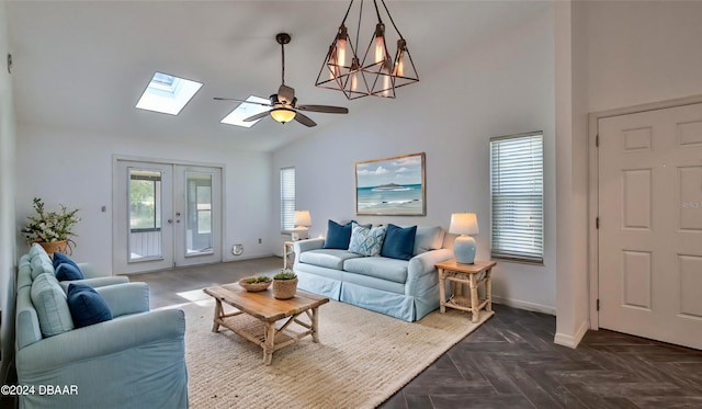 living room featuring french doors, dark parquet floors, high vaulted ceiling, an inviting chandelier, and a skylight