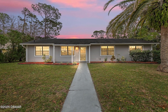 single story home featuring a lawn