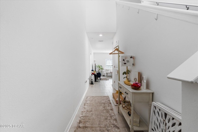 corridor featuring light tile patterned floors and baseboards