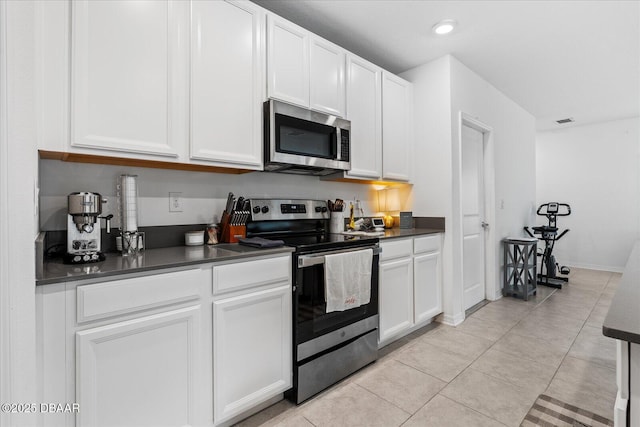 1223 Cabot Cliffs Dr, Daytona Beach, FL 32124 - kitchen featuring dark countertops, visible vents, appliances with stainless steel finishes, and light tile patterned floors