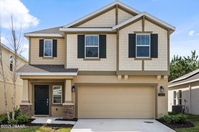 view of front of home with a garage, a shingled roof, concrete driveway, stone siding, and stucco siding