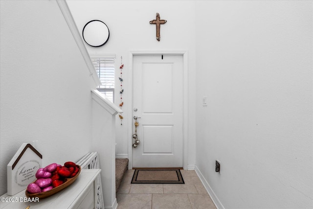 interior space featuring baseboards and light tile patterned flooring