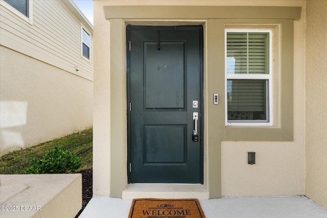 entrance to property featuring stucco siding