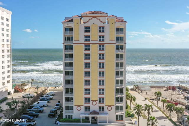 view of property with a water view and a view of the beach