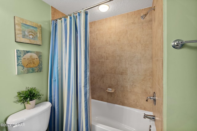 bathroom with shower / tub combo with curtain, a textured ceiling, and toilet